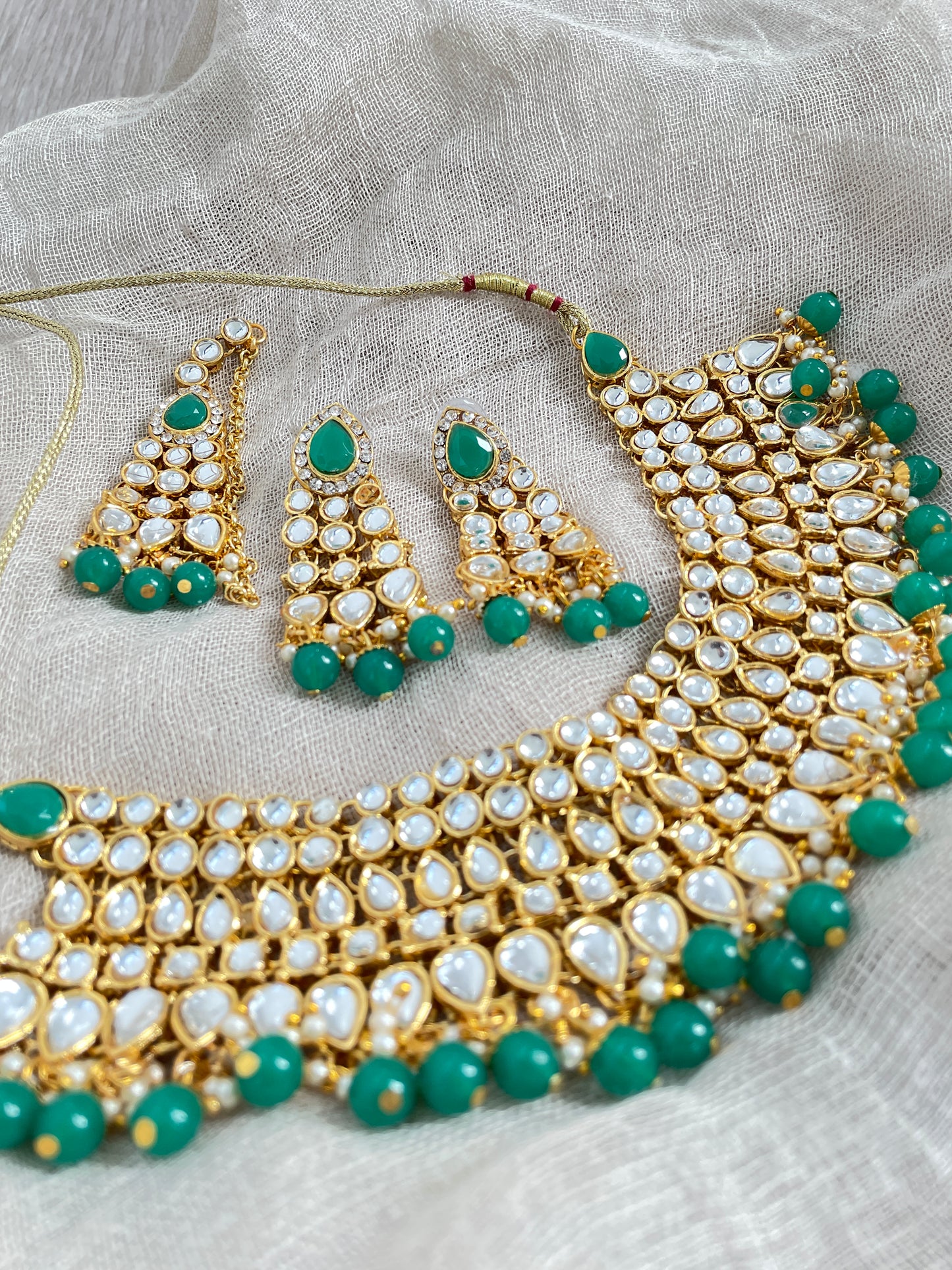 Gold-colored jewelry set with green details