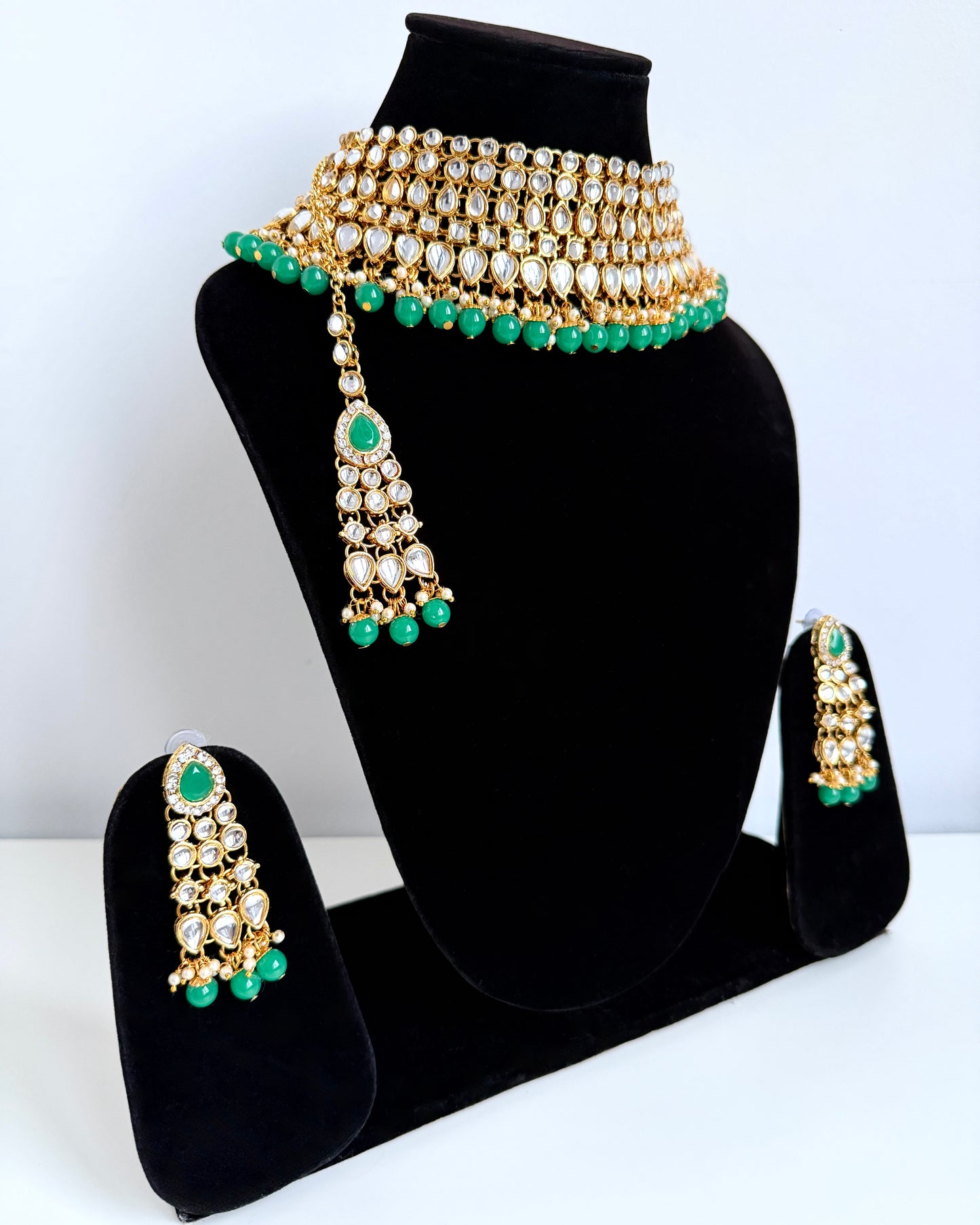 Goudkleurige sieradenset met groene details