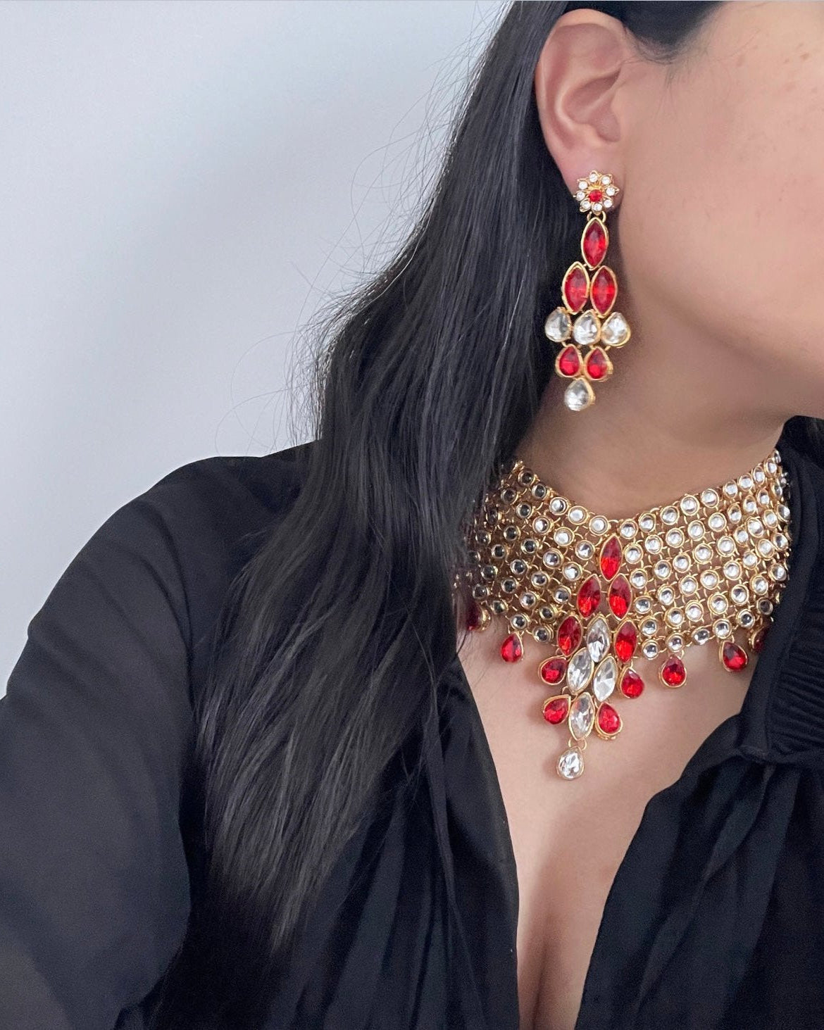 Gold-colored jewelry set with red crystal stones