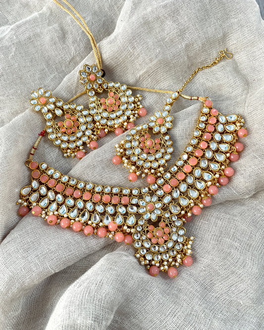 Goudkleurige sieradenset met roze stenen